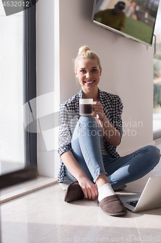 Image of young woman drinking coffee enjoying relaxing lifestyle