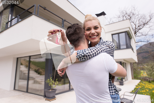 Image of couple hugging in front of  new luxury home