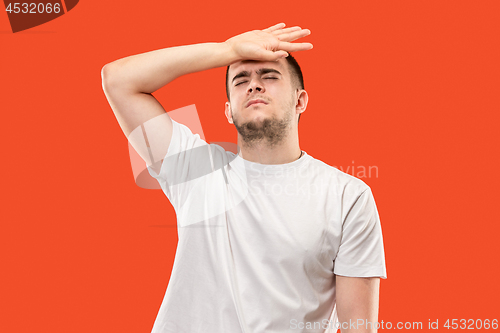 Image of Man having headache. Isolated over orang background.