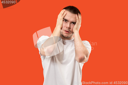 Image of Man having headache. Isolated over orang background.