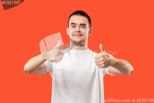 Image of The happy businessman standing and smiling against red background.