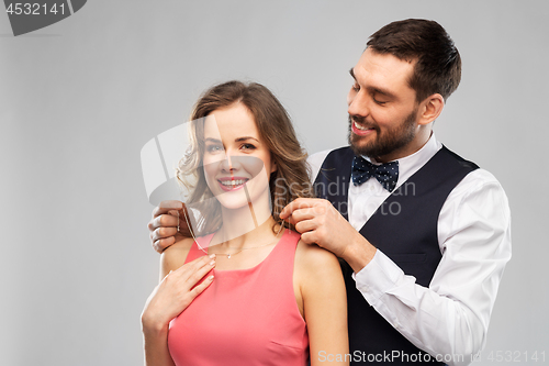 Image of happy man puts necklace on his girlfriend