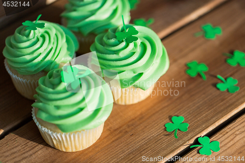 Image of green cupcakes and shamrock on wooden table