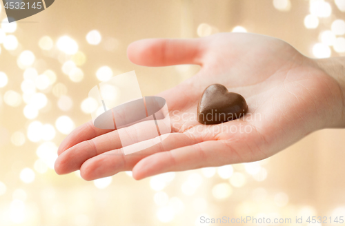 Image of close up of hand with heart shaped chocolate candy