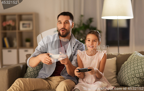 Image of father and daughter playing video game at home