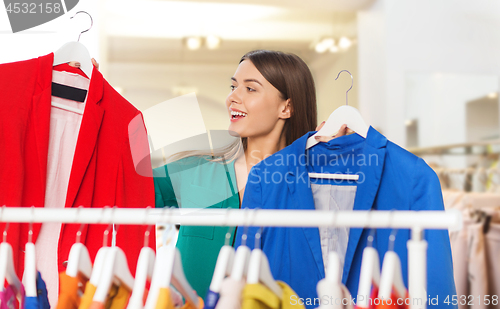 Image of happy woman choosing clothes at clothing store