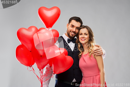 Image of happy couple with red heart shaped balloons