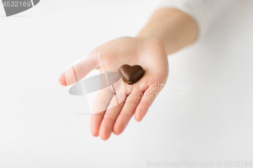 Image of close up of hand with heart shaped chocolate candy