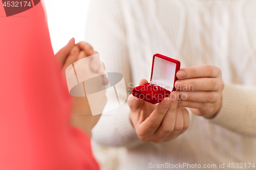 Image of man giving diamond ring to woman on valentines day