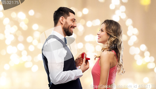 Image of man giving woman engagement ring on valentines day