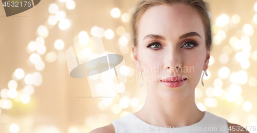 Image of woman in white dress with diamond earring