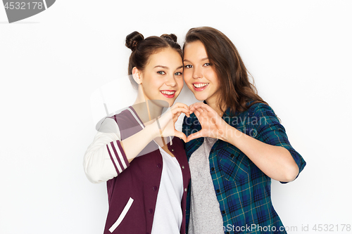 Image of happy smiling teenage girls showing heart sing