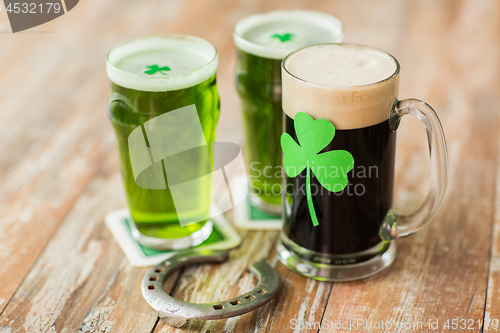 Image of shamrock on glass of beer and horseshoe on table