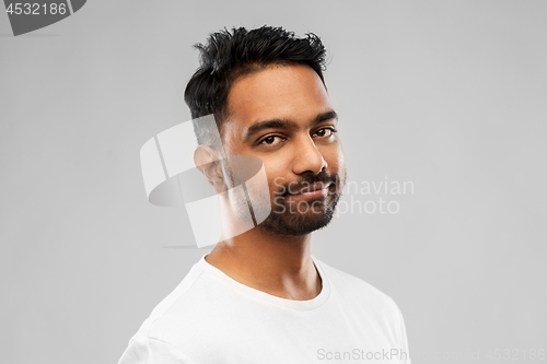 Image of smiling young indian man over gray background