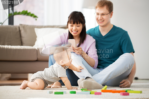 Image of mixed race family with baby son playing at home