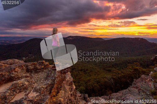 Image of Woman watching storm clouds over Blue Mountains at sunset