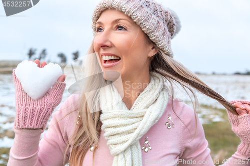 Image of Exuberant woman holding a heart of snow