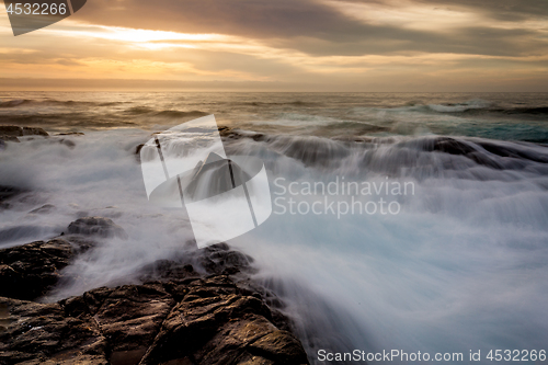 Image of Mystical light over the ocean  with rocky ocean cascades