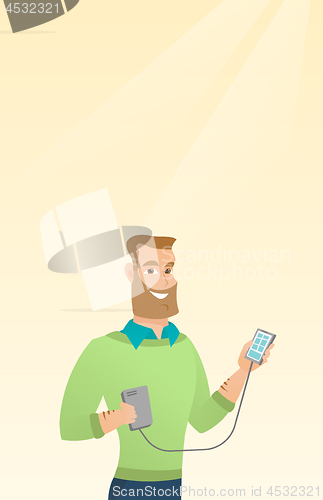 Image of Man reharging smartphone from portable battery.
