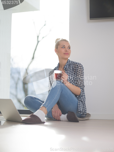 Image of young woman drinking coffee enjoying relaxing lifestyle
