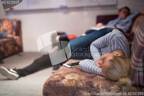 Image of software developers sleeping on sofa in creative startup office