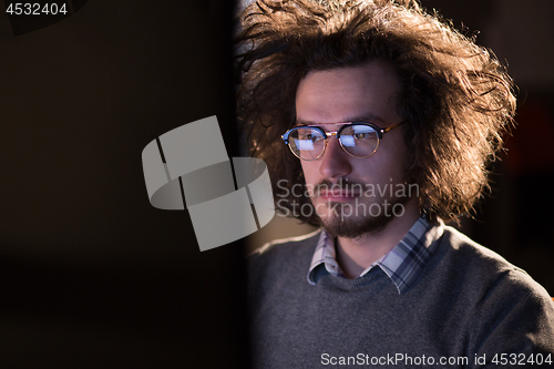 Image of man working on computer in dark office