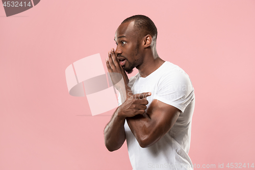 Image of The young man whispering a secret behind her hand