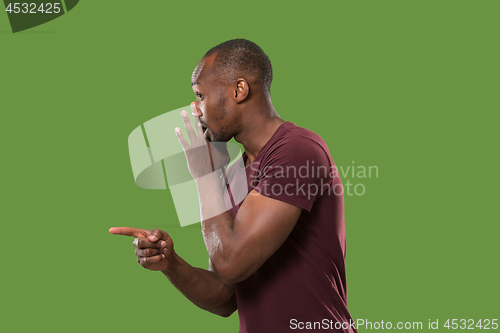 Image of The young man whispering a secret behind her hand