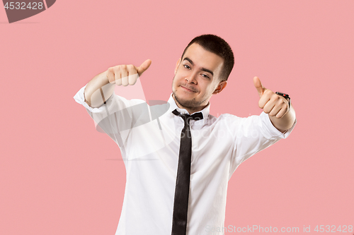 Image of The happy businessman standing and smiling against pink background.