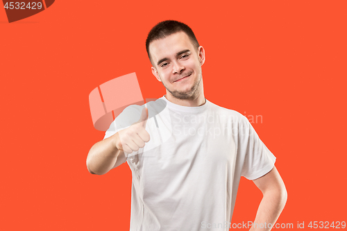 Image of The happy businessman standing and smiling against red background.