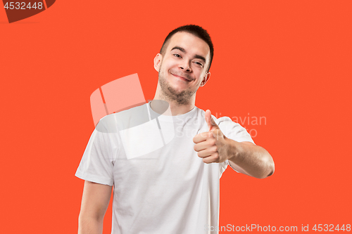 Image of The happy businessman standing and smiling against red background.