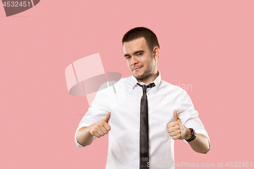 Image of The happy businessman standing and smiling against pink background.