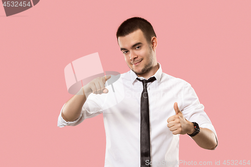 Image of The happy businessman standing and smiling against pink background.