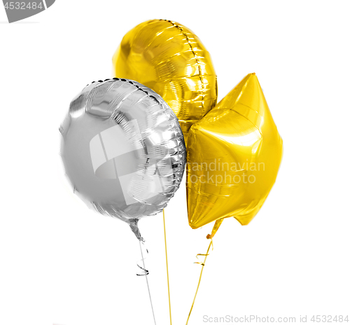 Image of three gold and silver helium balloons on white