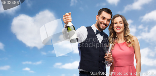 Image of happy couple with bottle of champagne and glasses