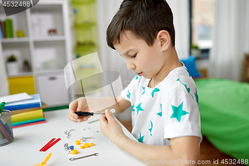 Image of little boy playing with building kit at home