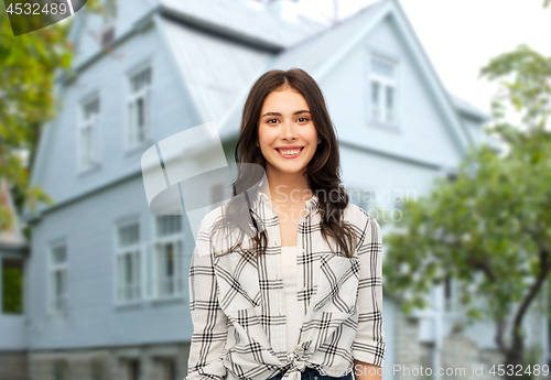 Image of teenage girl in checkered shirt over house