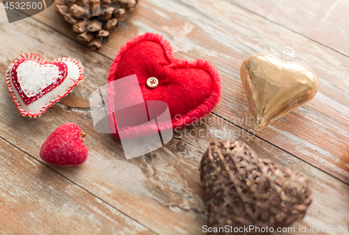 Image of heart shaped decorations on wooden background