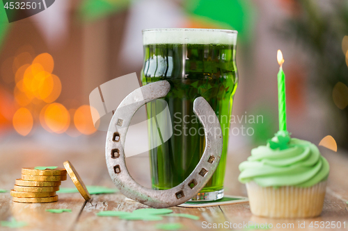 Image of glass of beer, cupcake, horseshoe and gold coins