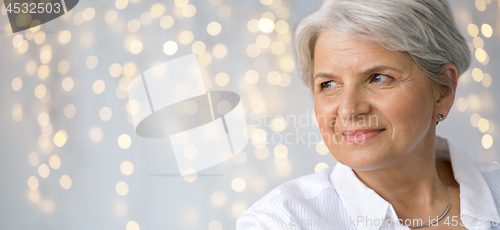 Image of portrait of senior woman over festive lights