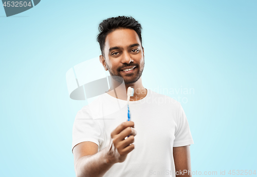 Image of indian man with toothbrush over blue background