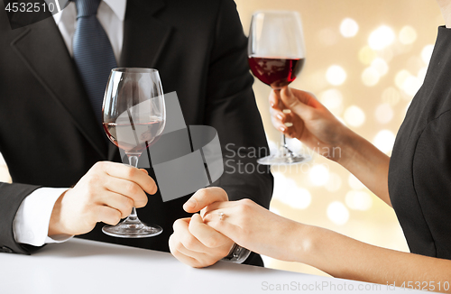 Image of close up of engaged couple drinking red wine