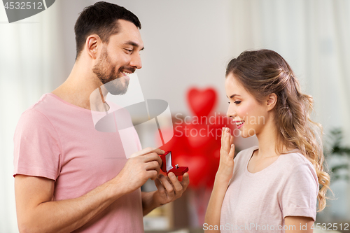 Image of man giving woman engagement ring on valentines day