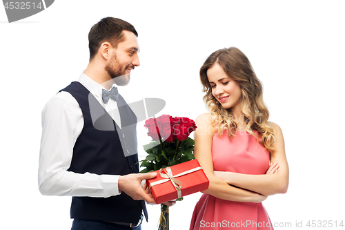 Image of happy man giving woman flowers and present