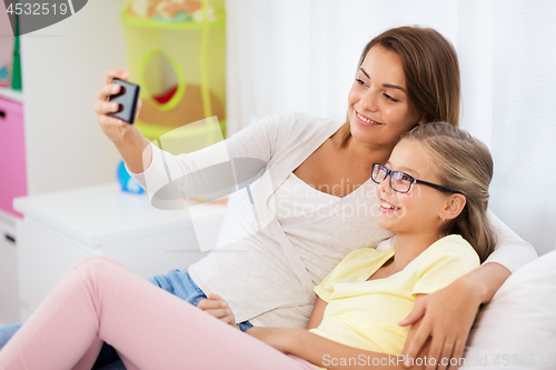 Image of happy family taking selfie by smartphone at home