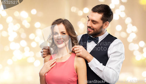 Image of happy man puts necklace on his girlfriend