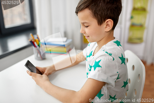 Image of happy boy with smartphone at home