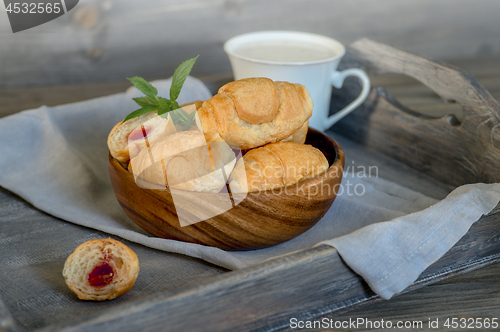 Image of Croissants on a wooden tray. The concept of a wholesome breakfast.