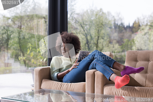 Image of young african american woman at home using digital tablet