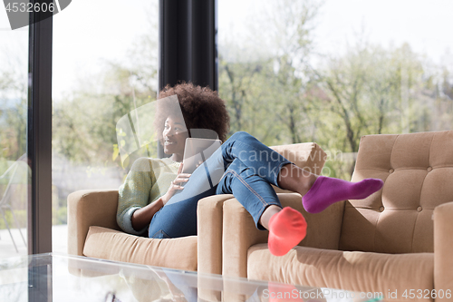 Image of young african american woman at home using digital tablet